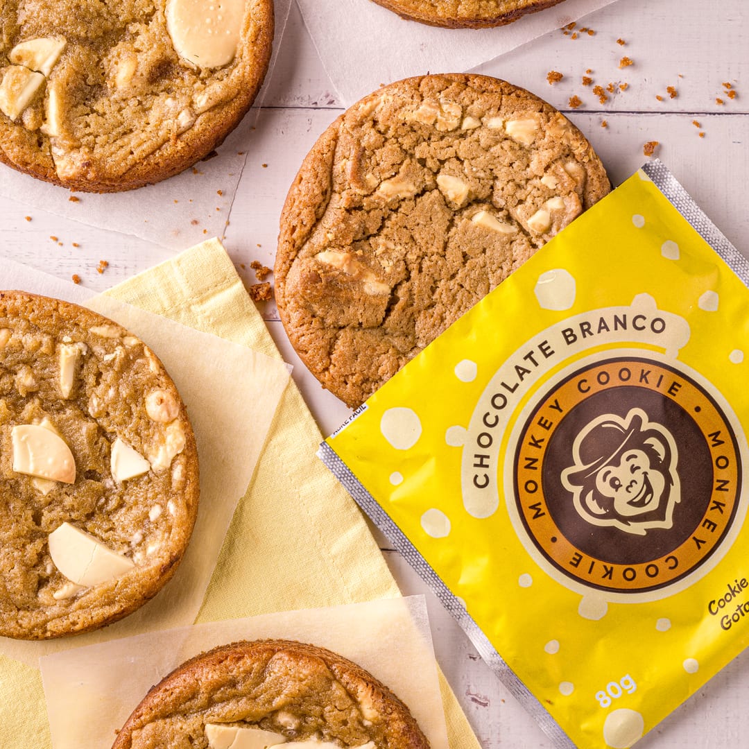 Cookies de chocolate branco ao redor do pack amarelo Chocolate Branco da Monkey Cookie